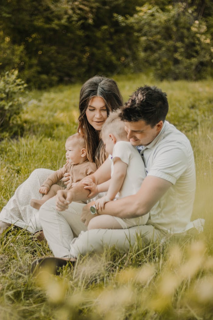 A family enjoys a tender moment outdoors, highlighting love and connection in summer scenery.