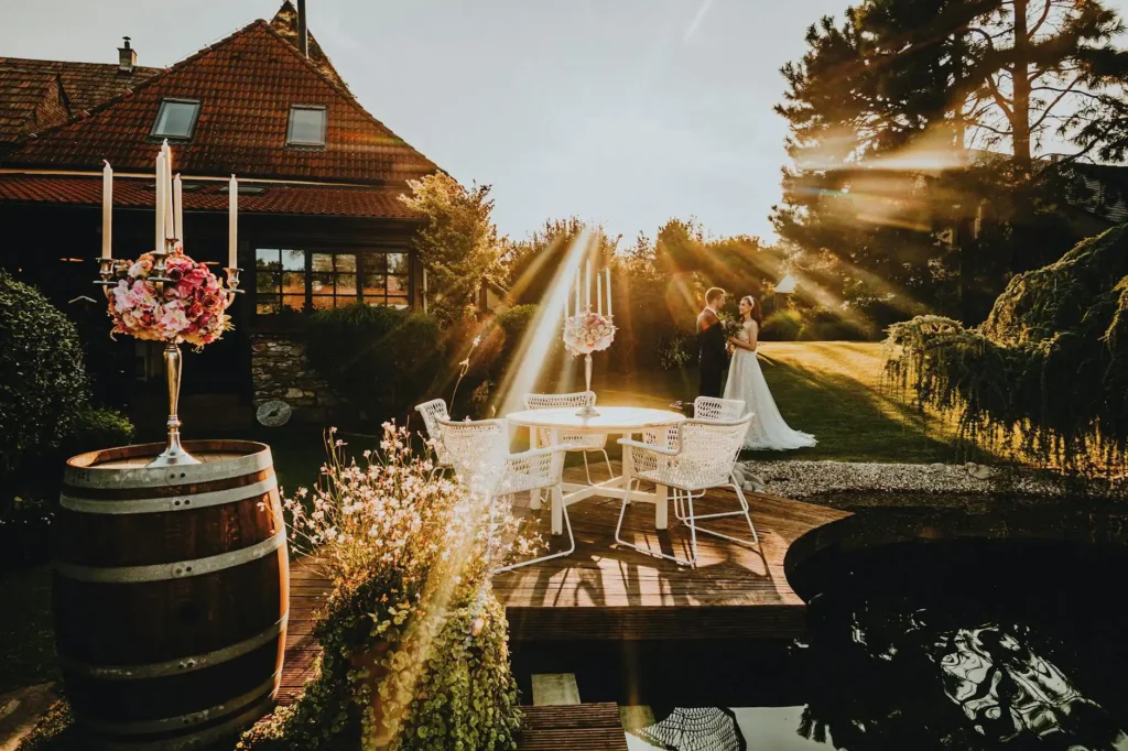 A bride and groom share a moment in a sunlit garden wedding scene surrounded by nature.