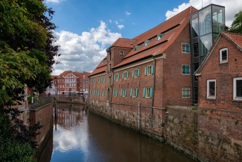Scenic view of brick buildings and canal in historic European town under blue sky.