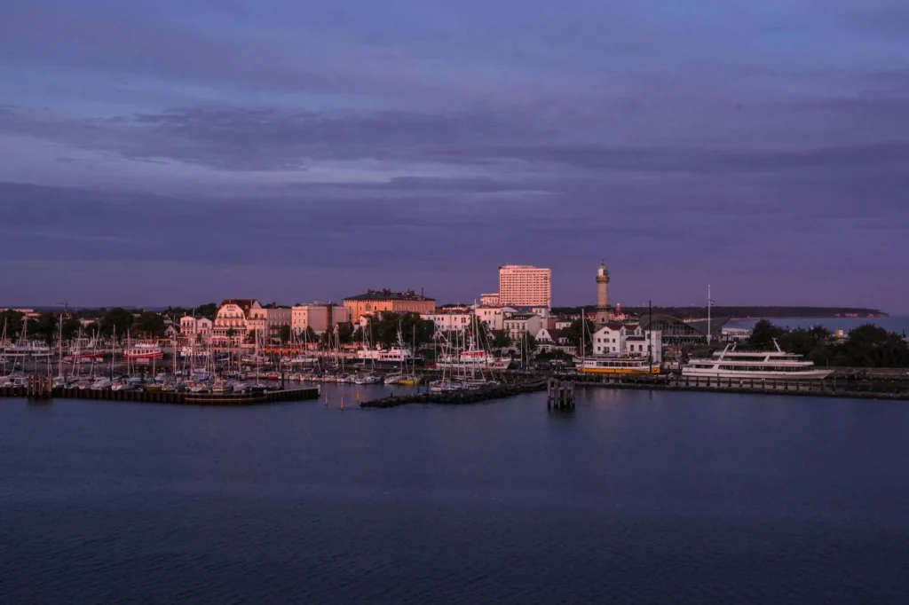 Beautiful coastal town harbor with boats at sunset, serene waterfront view.