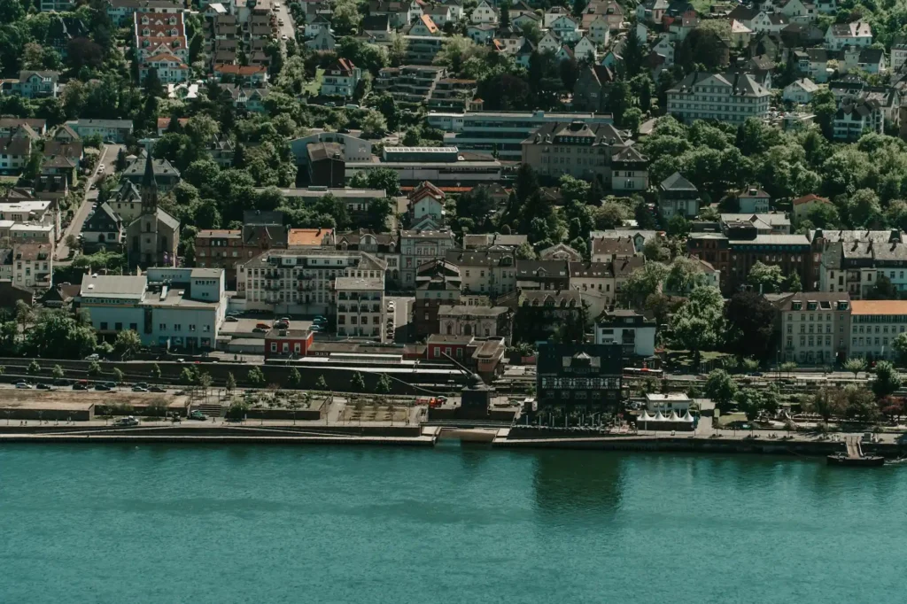 A captivating aerial view of a picturesque town by the river, surrounded by lush greenery.