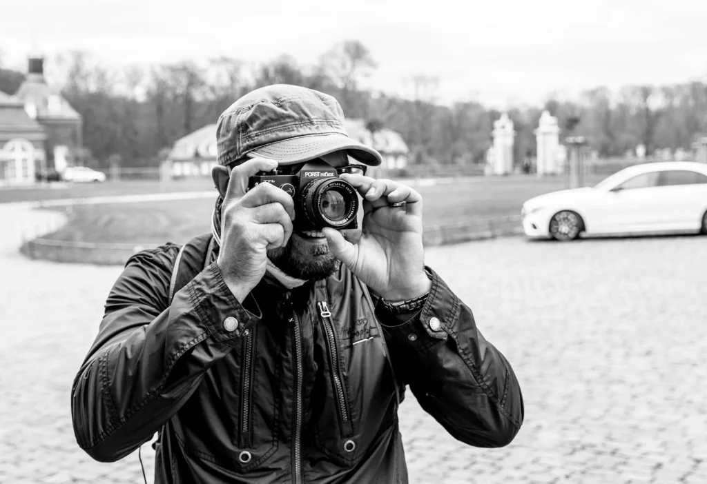 A photographer captures a moment in a German setting, focusing with a vintage camera.