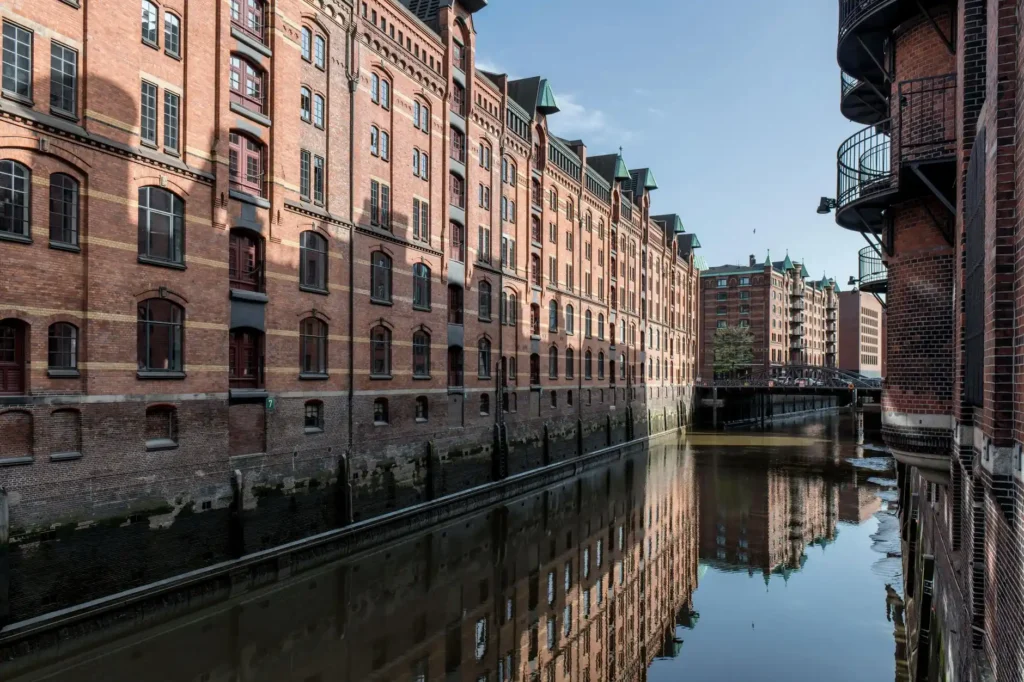 Beautiful view of Hamburg's Speicherstadt with red brick buildings reflecting on the canal.