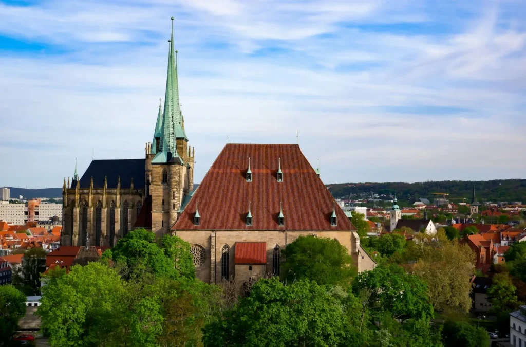 Stunning aerial view of a Gothic cathedral in a vibrant cityscape, bathed in summer light.