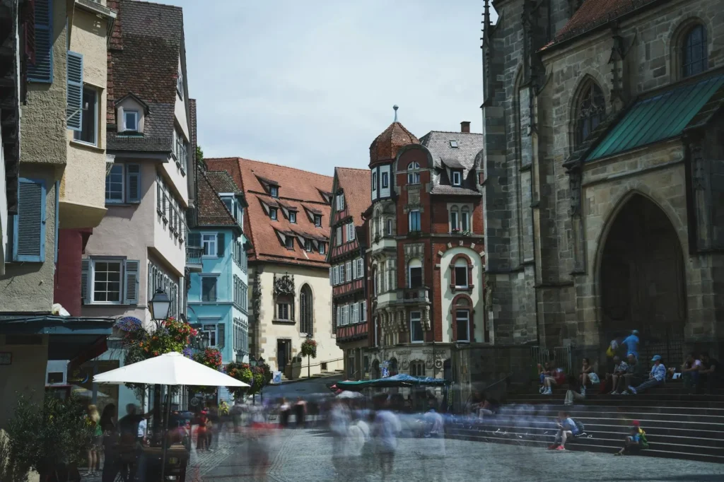 Charming medieval street scene with blurred crowds and historic architecture.