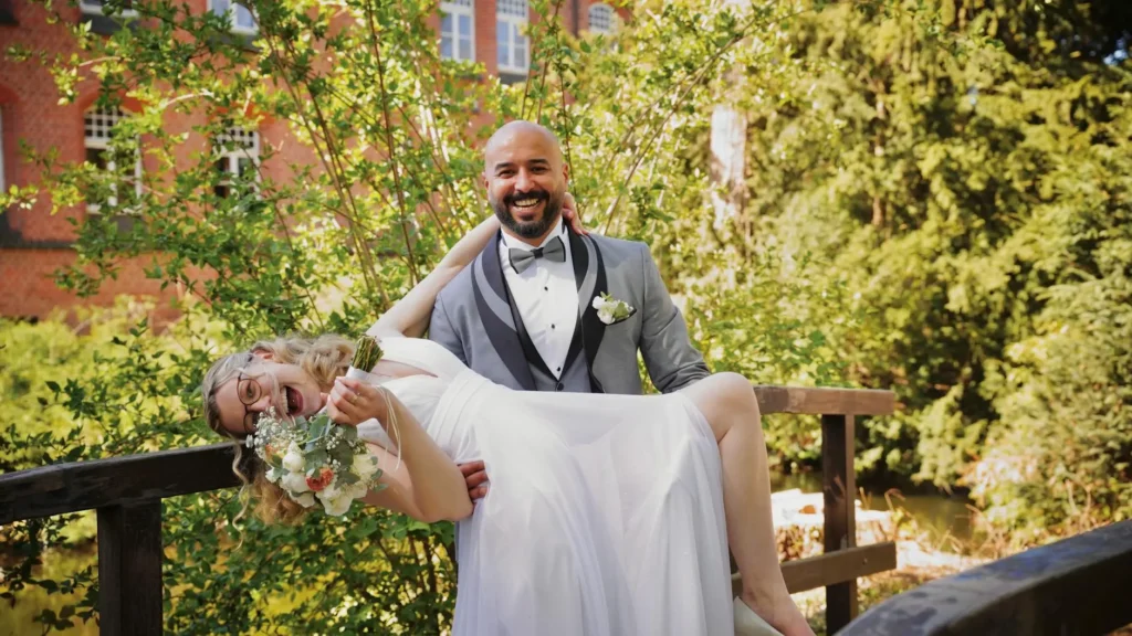 Bride and groom sharing a joyful moment outdoors in Hamburg garden.