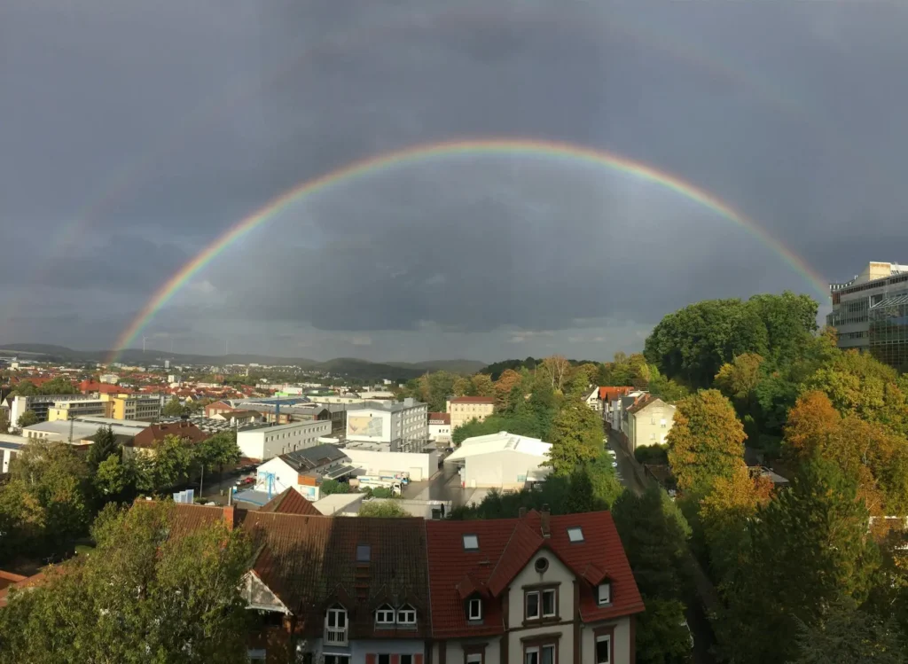 Double rainbow arches over Kaiserslautern, Germany, showcasing vibrant nature after the rain.